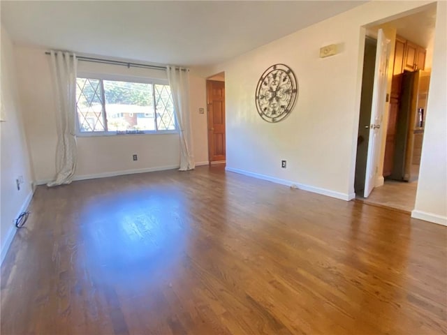unfurnished room featuring baseboards and wood finished floors