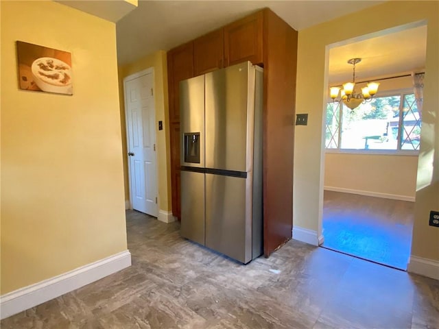 kitchen featuring stainless steel fridge with ice dispenser, baseboards, and a chandelier