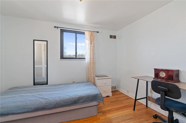 bedroom featuring light wood-style floors and visible vents