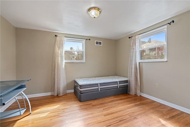 bedroom featuring light wood-style floors, baseboards, and visible vents