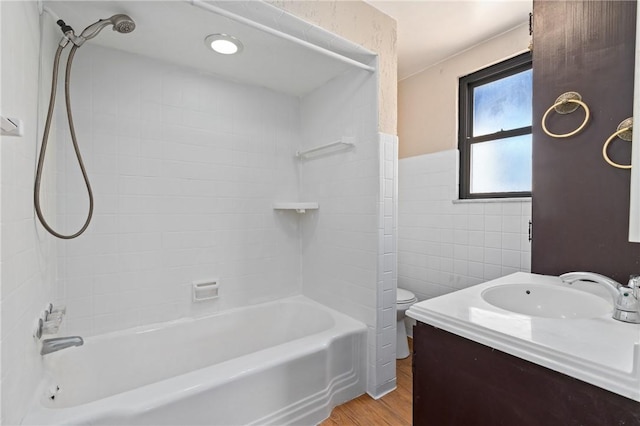 full bathroom featuring vanity, toilet, shower / bath combination, wood finished floors, and tile walls