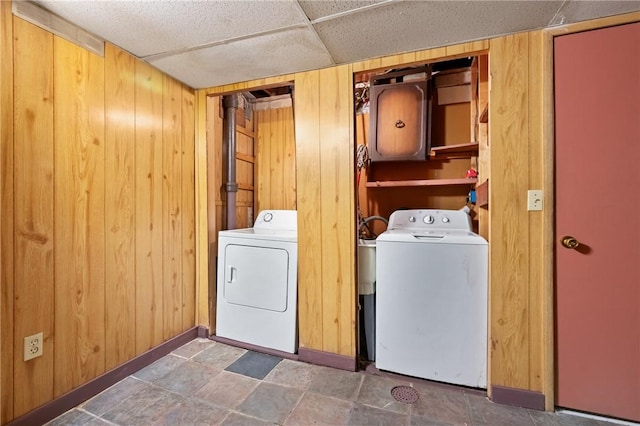 laundry room with wood walls, independent washer and dryer, and laundry area