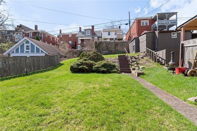 view of yard featuring a shed, a fenced backyard, and an outdoor structure