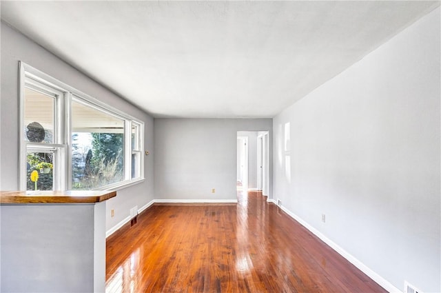 unfurnished room with baseboards and wood finished floors
