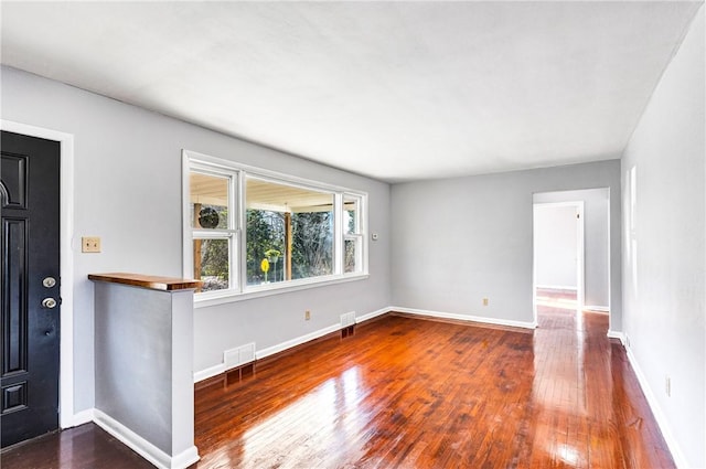 interior space with visible vents, hardwood / wood-style flooring, and baseboards