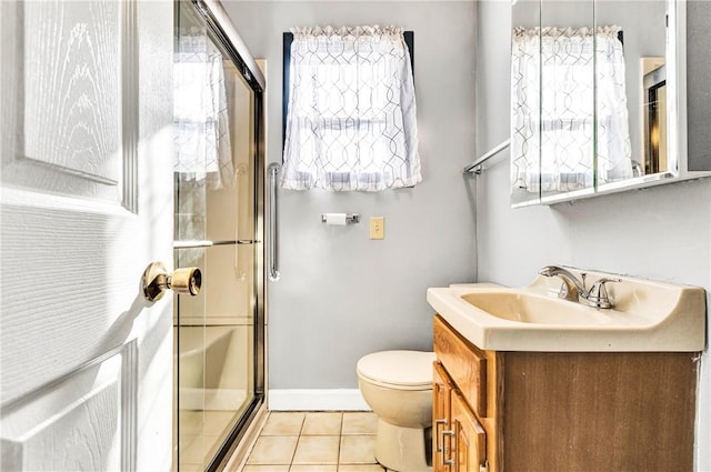 bathroom with a shower stall, tile patterned floors, vanity, baseboards, and toilet