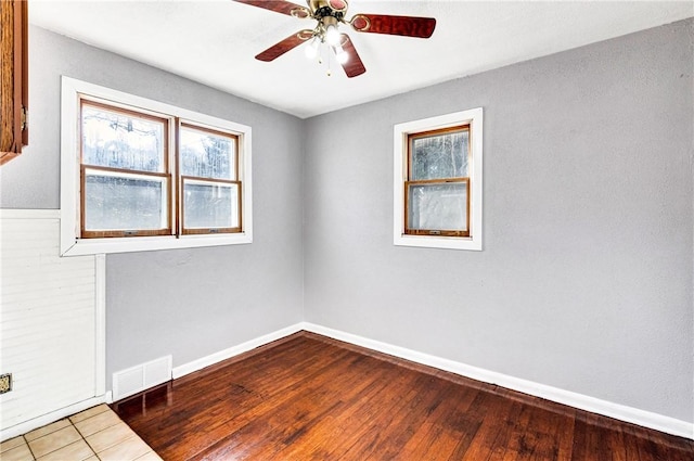 empty room with baseboards, visible vents, a wealth of natural light, and ceiling fan