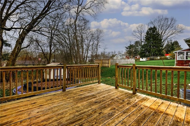 wooden deck featuring a fenced backyard and a yard