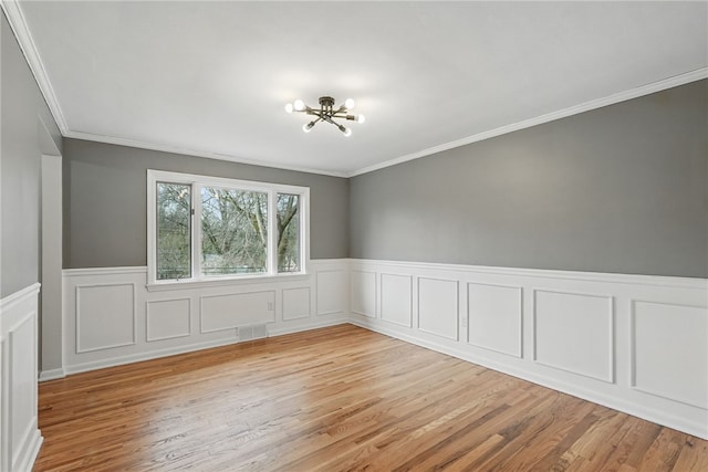 285 Park Entrance Dr, Mt Lebanon, PA 15228 - spare room with visible vents, a notable chandelier, crown molding, wainscoting, and light wood-style flooring