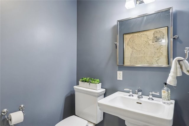 half bathroom featuring a sink and toilet