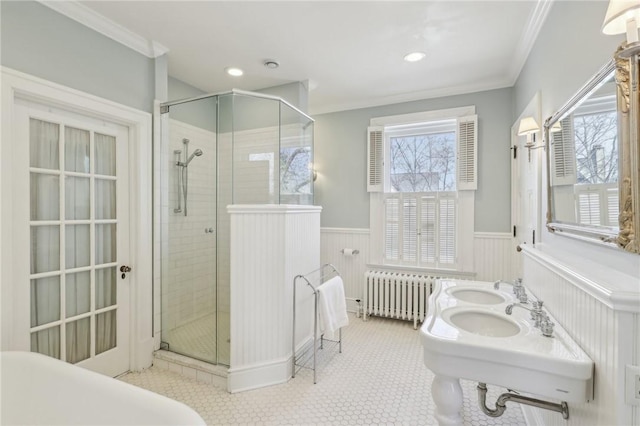 bathroom featuring ornamental molding, radiator, and wainscoting