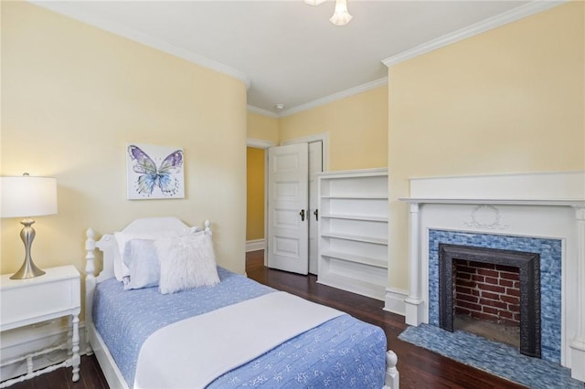 bedroom featuring ornamental molding, baseboards, wood finished floors, and a fireplace with flush hearth