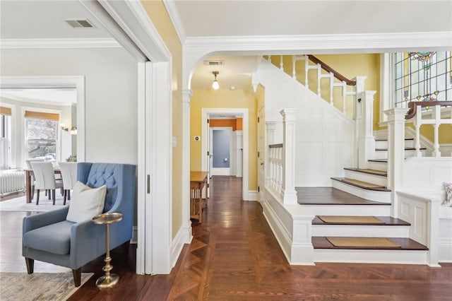 entryway with visible vents, baseboards, ornamental molding, stairs, and radiator heating unit