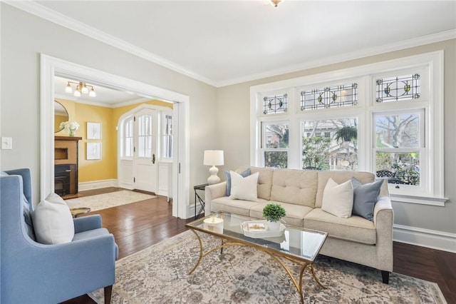 living area featuring dark wood-type flooring, crown molding, and a healthy amount of sunlight