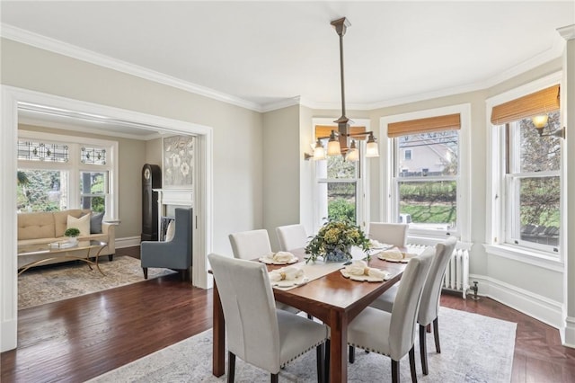 dining area with a chandelier, crown molding, baseboards, and dark wood finished floors