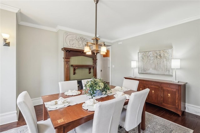 dining space featuring ornamental molding, baseboards, and dark wood-style floors