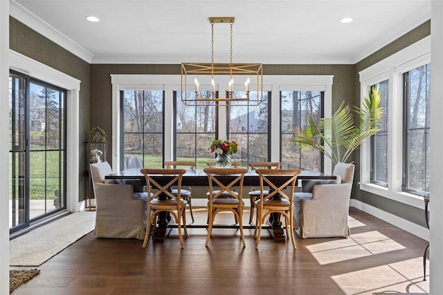 dining room with a chandelier, wood finished floors, crown molding, and a healthy amount of sunlight