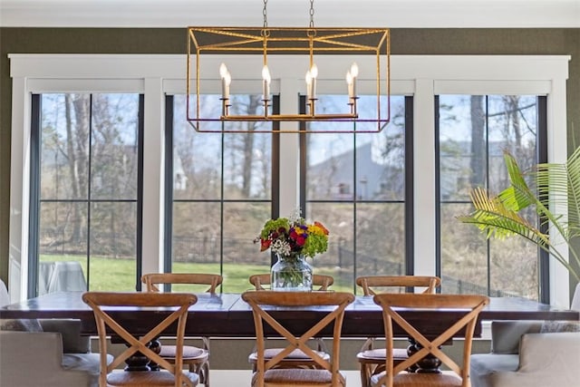 sunroom featuring a chandelier and plenty of natural light