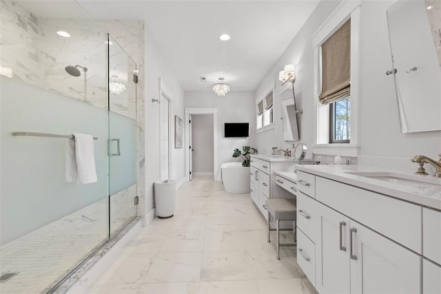 bathroom featuring a freestanding tub, a sink, a marble finish shower, two vanities, and marble finish floor