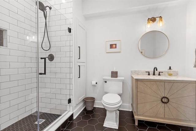 full bath with baseboards, toilet, vanity, tile patterned flooring, and a stall shower