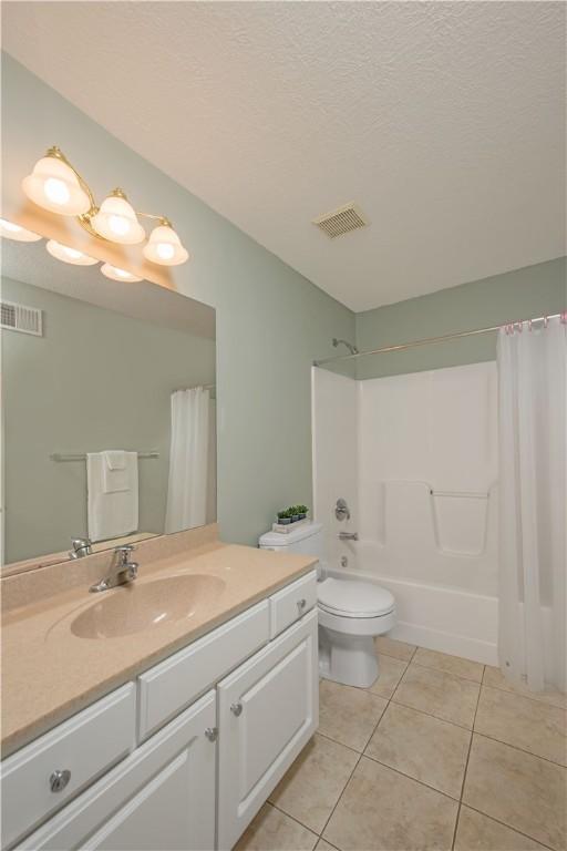 bathroom featuring toilet, tile patterned floors, vanity, and visible vents