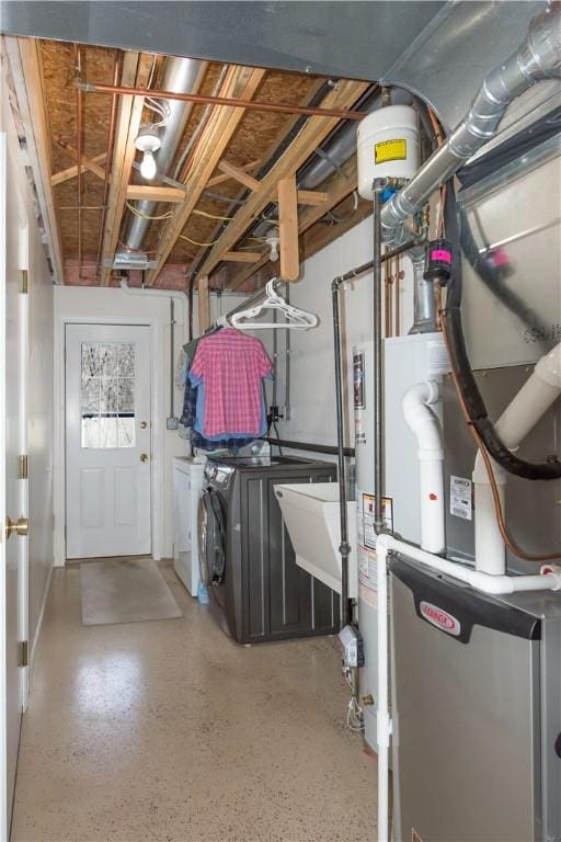 basement featuring gas water heater, independent washer and dryer, a sink, and heating unit