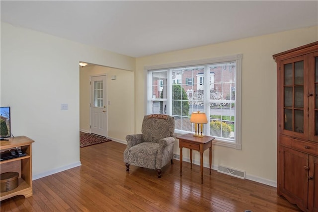 sitting room with hardwood / wood-style floors, baseboards, and visible vents