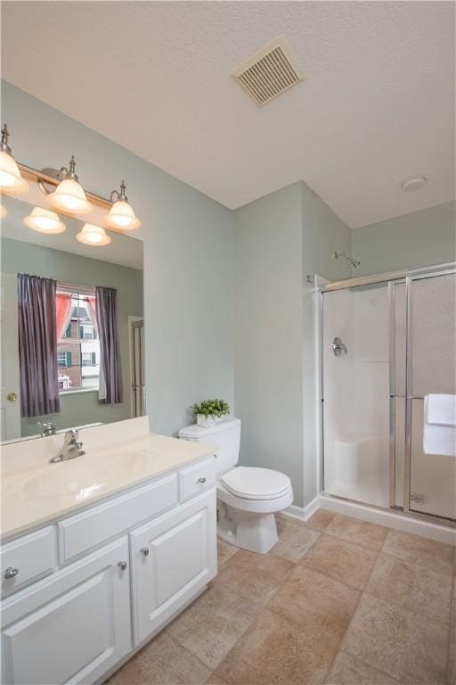 bathroom featuring toilet, a stall shower, vanity, and visible vents