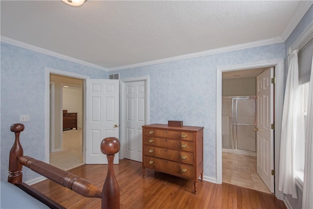 bedroom featuring visible vents, ornamental molding, wood finished floors, and wallpapered walls