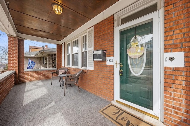 property entrance featuring brick siding and covered porch