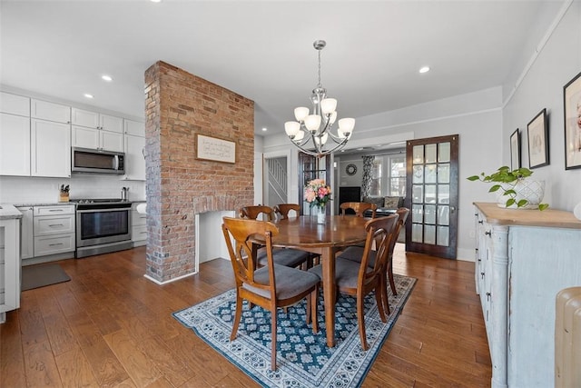 dining area with a chandelier, dark wood-type flooring, and recessed lighting