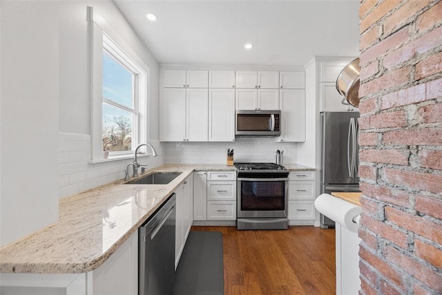 kitchen featuring stainless steel appliances, dark wood-type flooring, white cabinets, and a sink