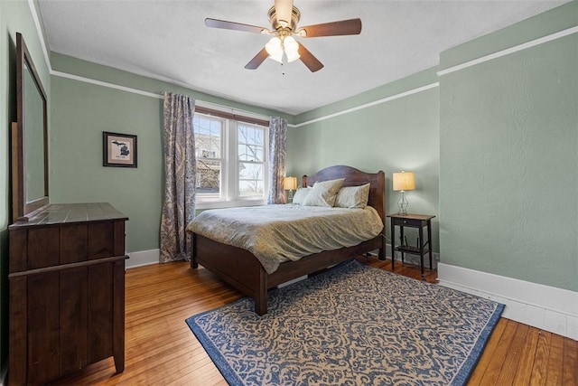 bedroom with wood-type flooring, baseboards, and a ceiling fan