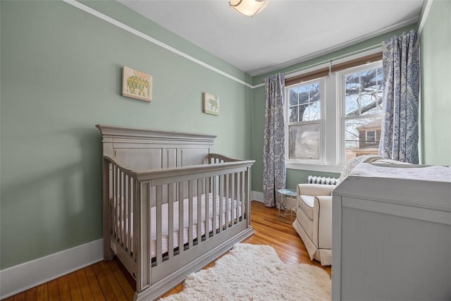 bedroom featuring wood finished floors and baseboards