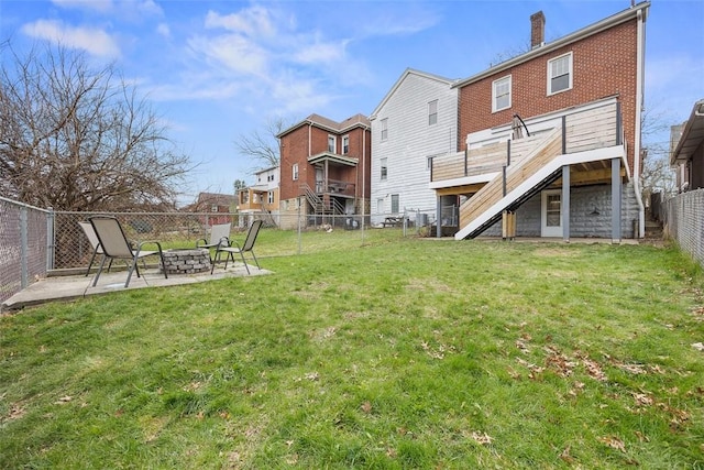 back of property with a fenced backyard, a lawn, an outdoor fire pit, a patio area, and stairs