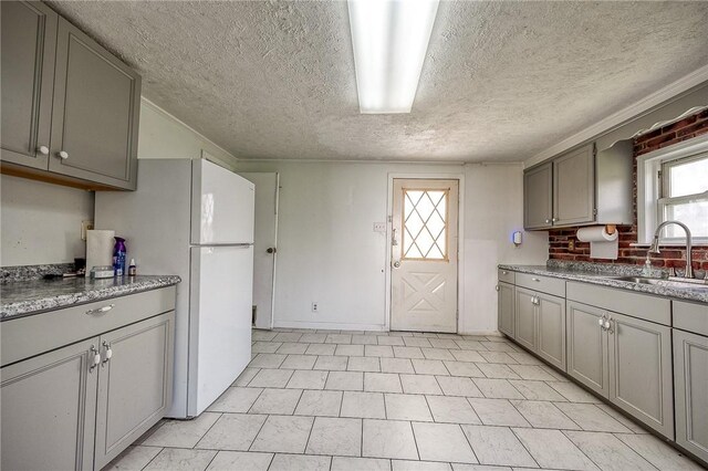 627 Rostraver Rd, Belle Vernon, PA 15012 - kitchen with a sink, freestanding refrigerator, gray cabinetry, and a textured ceiling