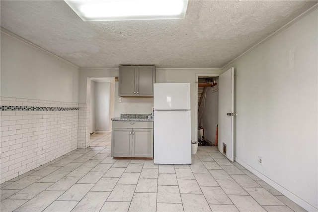 627 Rostraver Rd, Belle Vernon, PA 15012 - kitchen with gray cabinetry, freestanding refrigerator, and ornamental molding