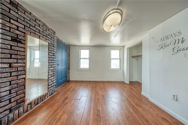 627 Rostraver Rd, Belle Vernon, PA 15012 - empty room featuring brick wall, baseboards, and hardwood / wood-style flooring