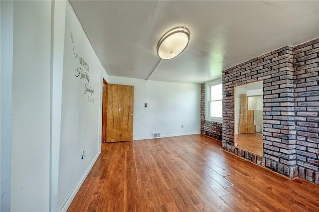 627 Rostraver Rd, Belle Vernon, PA 15012 - spare room with visible vents, brick wall, wood finished floors, and baseboards