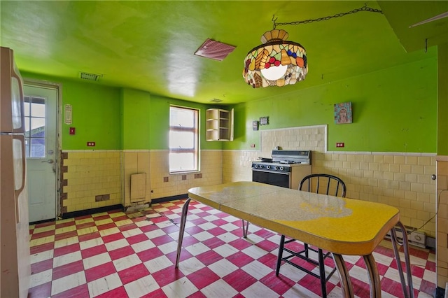 5179 Kincaid St, Garfield, PA 15224 - unfurnished dining area with visible vents, tile patterned floors, wainscoting, and a healthy amount of sunlight