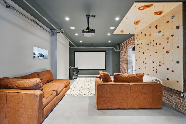 home theater featuring concrete flooring, recessed lighting, and brick wall