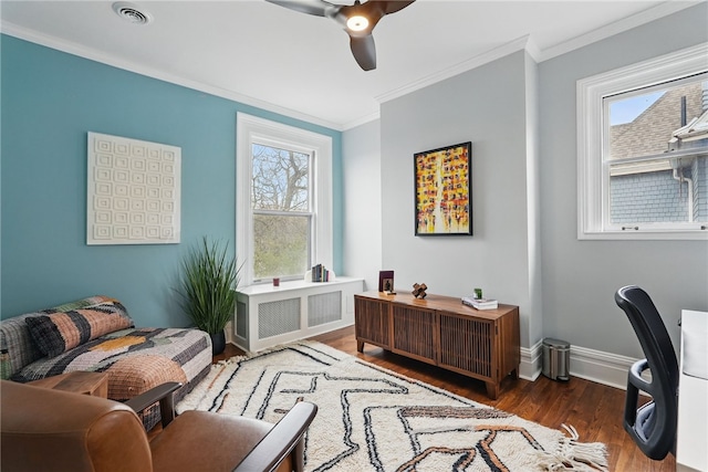 living area with visible vents, baseboards, a ceiling fan, crown molding, and wood finished floors