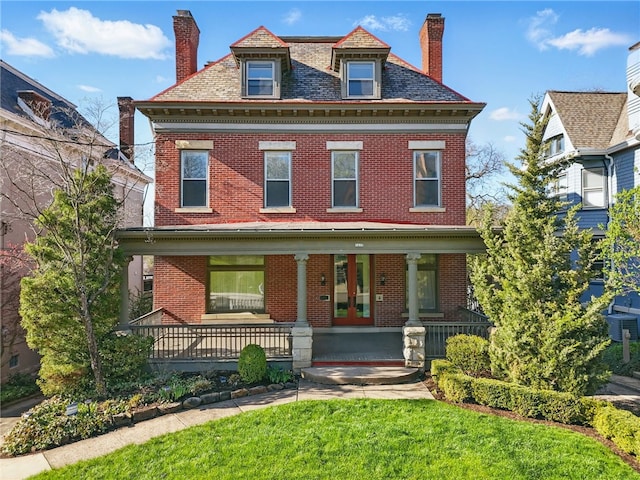 view of front facade with a porch, a high end roof, a chimney, brick siding, and french doors