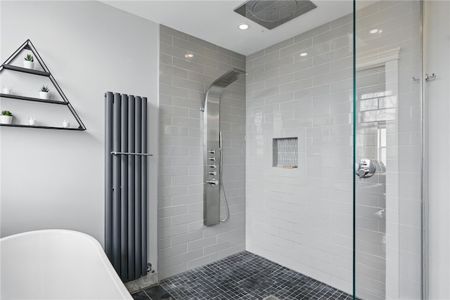 full bath with a freestanding bath, recessed lighting, and tiled shower