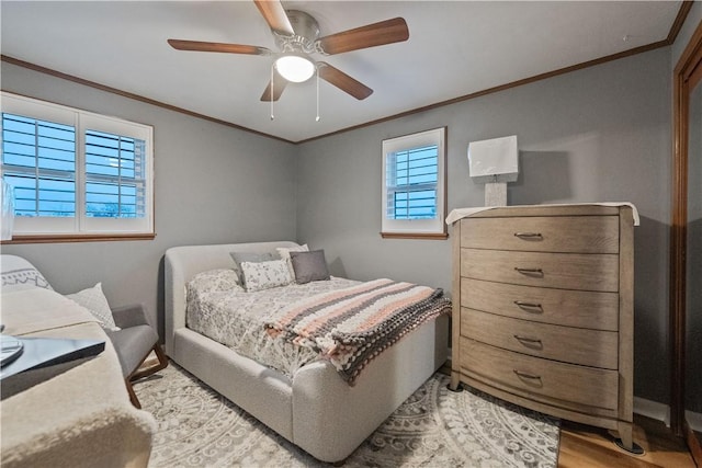 bedroom featuring light wood-style flooring, ornamental molding, and a ceiling fan