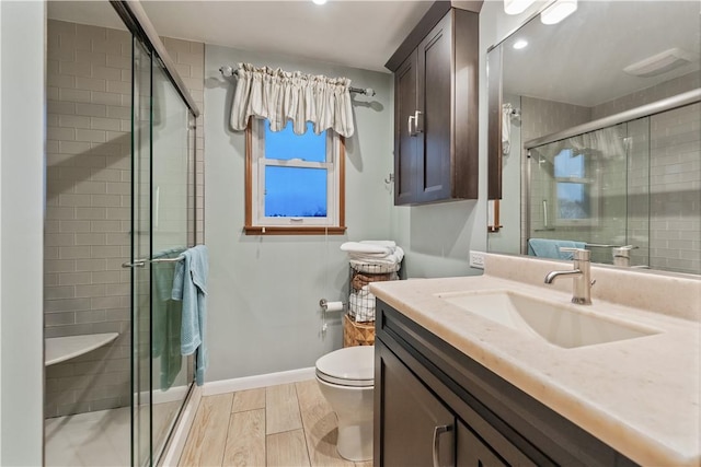bathroom with vanity, baseboards, and a stall shower