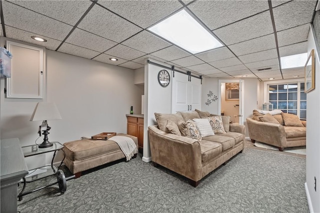 carpeted living room featuring visible vents and a drop ceiling