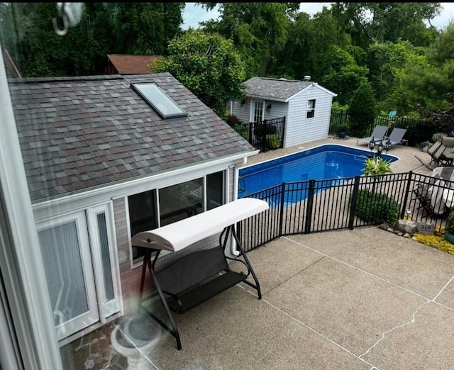 view of pool featuring a fenced in pool, a patio, fence, and an outbuilding
