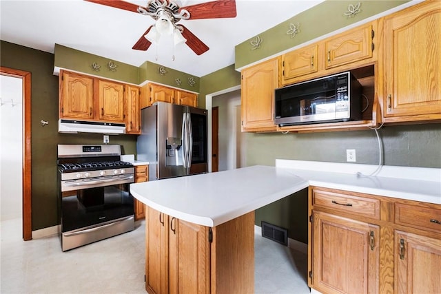 kitchen with light floors, visible vents, appliances with stainless steel finishes, under cabinet range hood, and light countertops