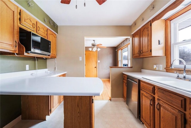kitchen featuring a sink, light countertops, ceiling fan, and dishwasher